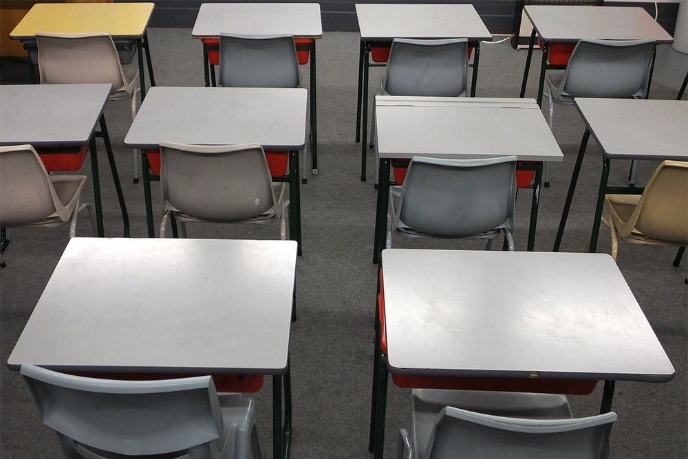 grey desk and chairs lined up.