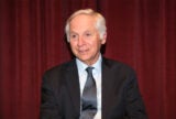 Mark Baldassare in a black suit and tie staring slightly to the left with a small smile.