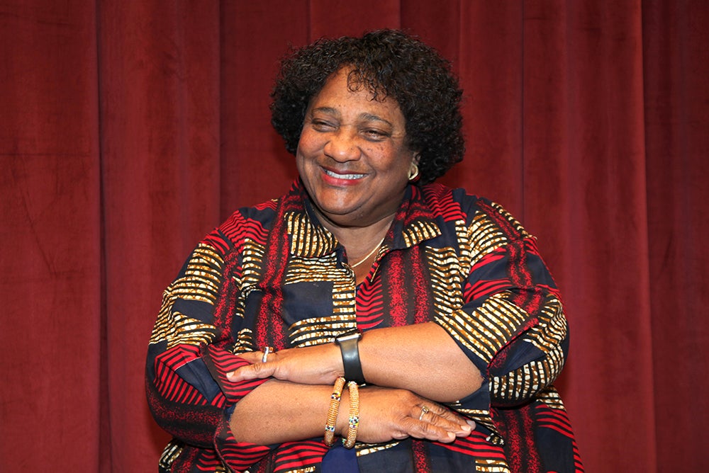 Shirley Weber in a patterned shirt looking slightly to the left with a smile and with arms almost crossed.